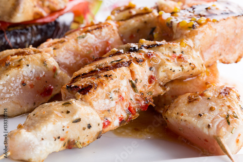 grilled chicken meat on stick on a plate