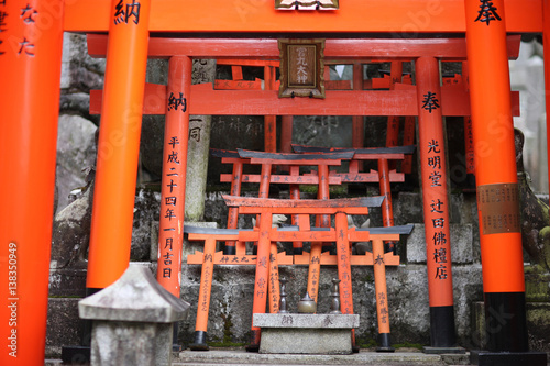 Red wooden sacrificial gate Torii with the names of donors on the territory of a Shinto temple © Anna Jurkovska