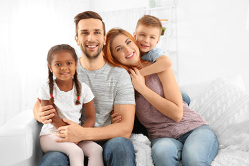Happy interracial family sitting on sofa