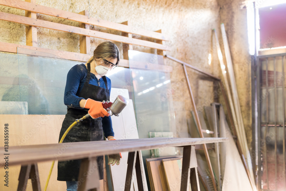 Woman painting table in a woodshop