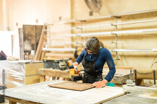 Young female carpenter at work