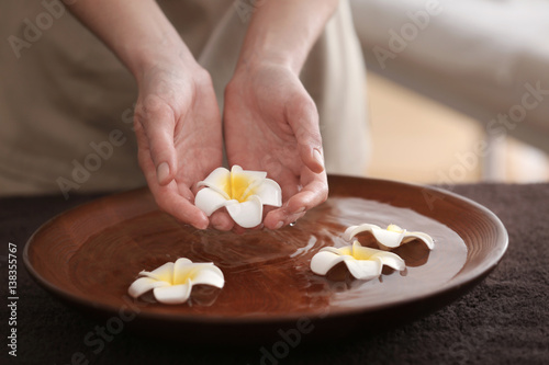 Spa concept. Female hands with bowl and exotic flowers