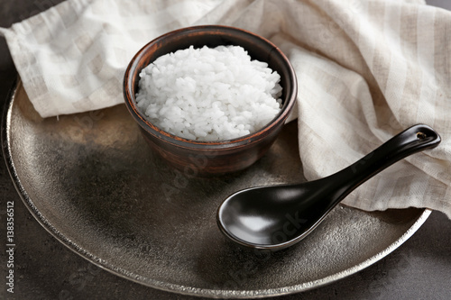 White rice in bowl with spoon, closeup