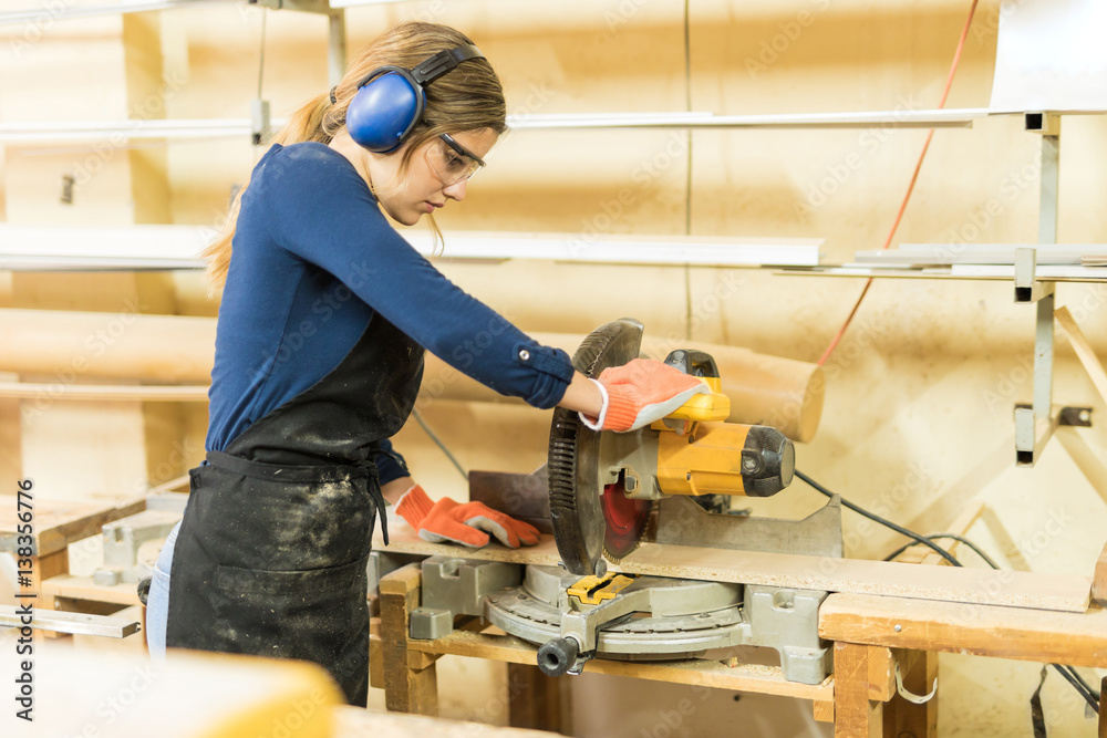 Woman using a circular saw Woman using a circular saw