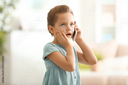 Cute little girl talking by...