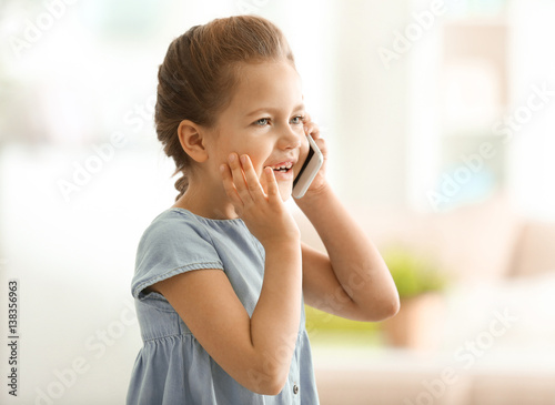 Cute little girl talking by...