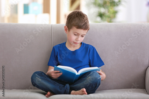 Little boy reading book on ...