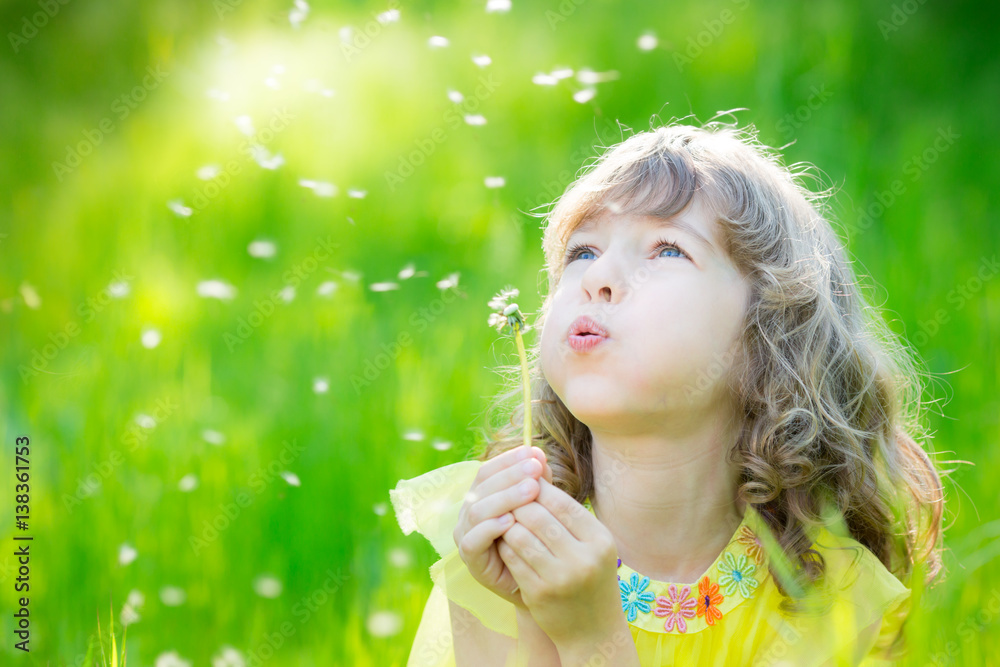 Happy child blowing dandelion flower outdoors Happy child blowing dandelion flower outdoors
