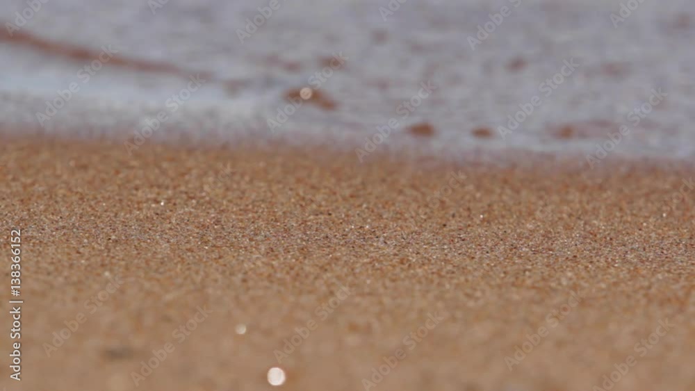 Clear water washes the sandy beach of Lake Baikal
