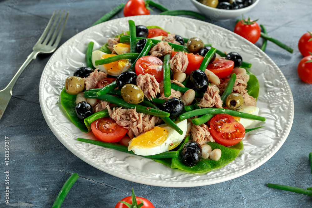 Fresh Tuna Green Bean salad with eggs, tomatoes, beans, olives on white plate. concept healthy food