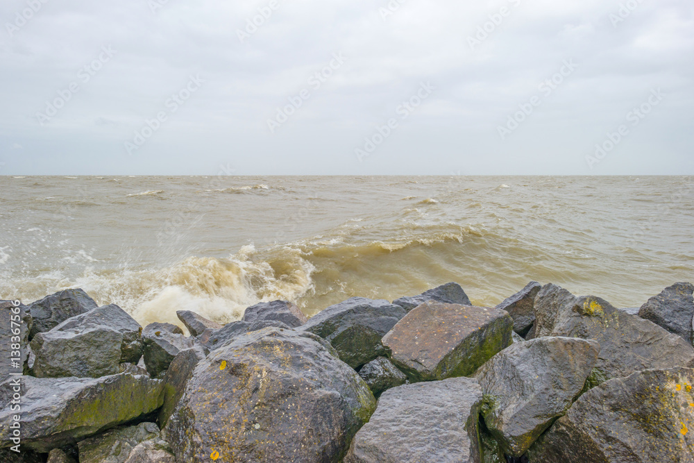 Dike along a stormy lake in winter Dike along a stormy lake in winter