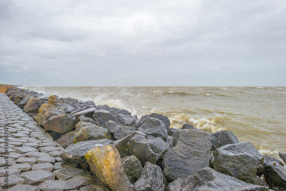 Dike along a stormy lake in winter Dike along a stormy lake in winter