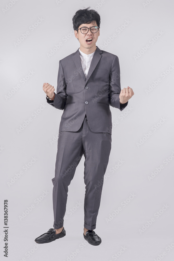 Young handsome business man in gray suit and glasses feel success with gray background Young handsome business man in gray suit and glasses feel success with gray background