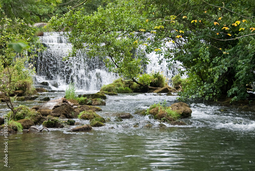 Derbyshire, UK - July 20 2014 - Waterfall at Monsal Dale Weir on the River Wye, Monsal Dale, UK photo