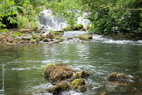 Derbyshire, UK - July 20 2014 - Waterfall at Monsal Dale Weir on the River Wye, Monsal Dale, UK