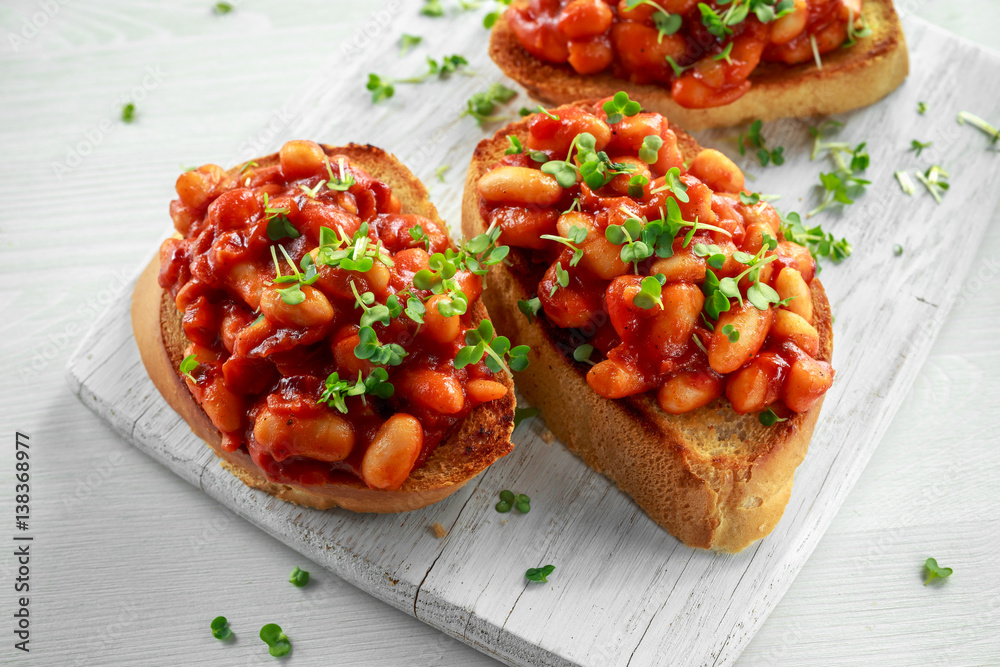 Beans fried in tomato sauce on toasted bread with cross salad sprinkle Beans fried in tomato sauce on toasted bread with cross salad sprinkle