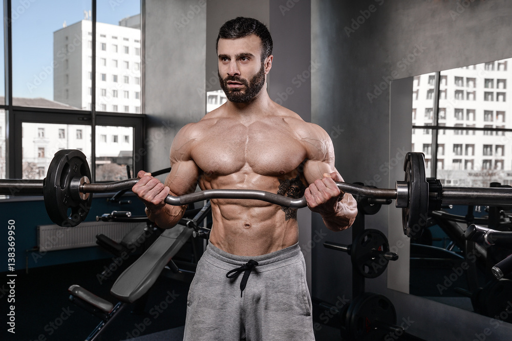 Handsome fitness model train in the gym gain muscle. Handsome fitness model train in the gym gain muscle.