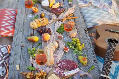 Picnic on the beach at sunset in boho style, food and drink concept © yatcenko