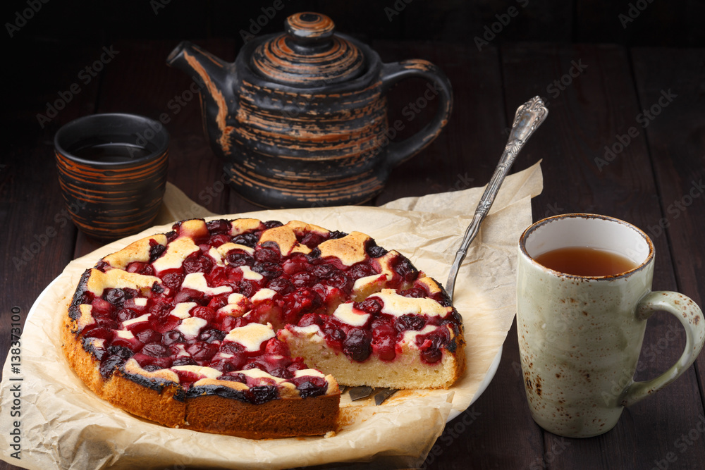 Homemade cherry pie with tea cup on wooden table Homemade cherry pie with tea cup on wooden table
