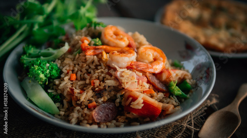 Vintage style Thai traditional food fried rice with shrimp on top and wooden background wallpaper