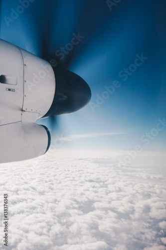 Propeller plane in air above the clouds
