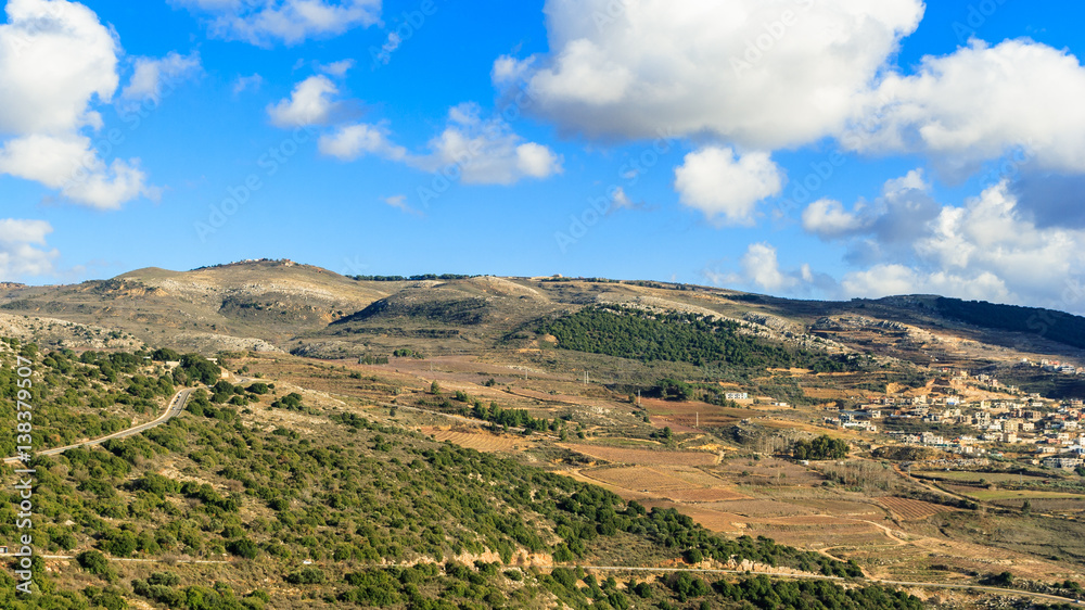 Upper Galilee mountains landscape, Golan Heights nature view from Nimrod, beautiful sunny day, blue sky with white clouds, druze village, Israel. Concept: discover travel destination