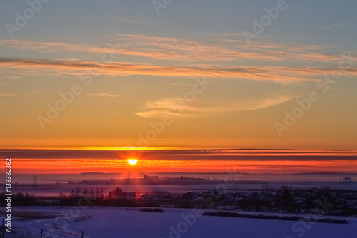 Beautiful sunrise with a red sun in the winter
