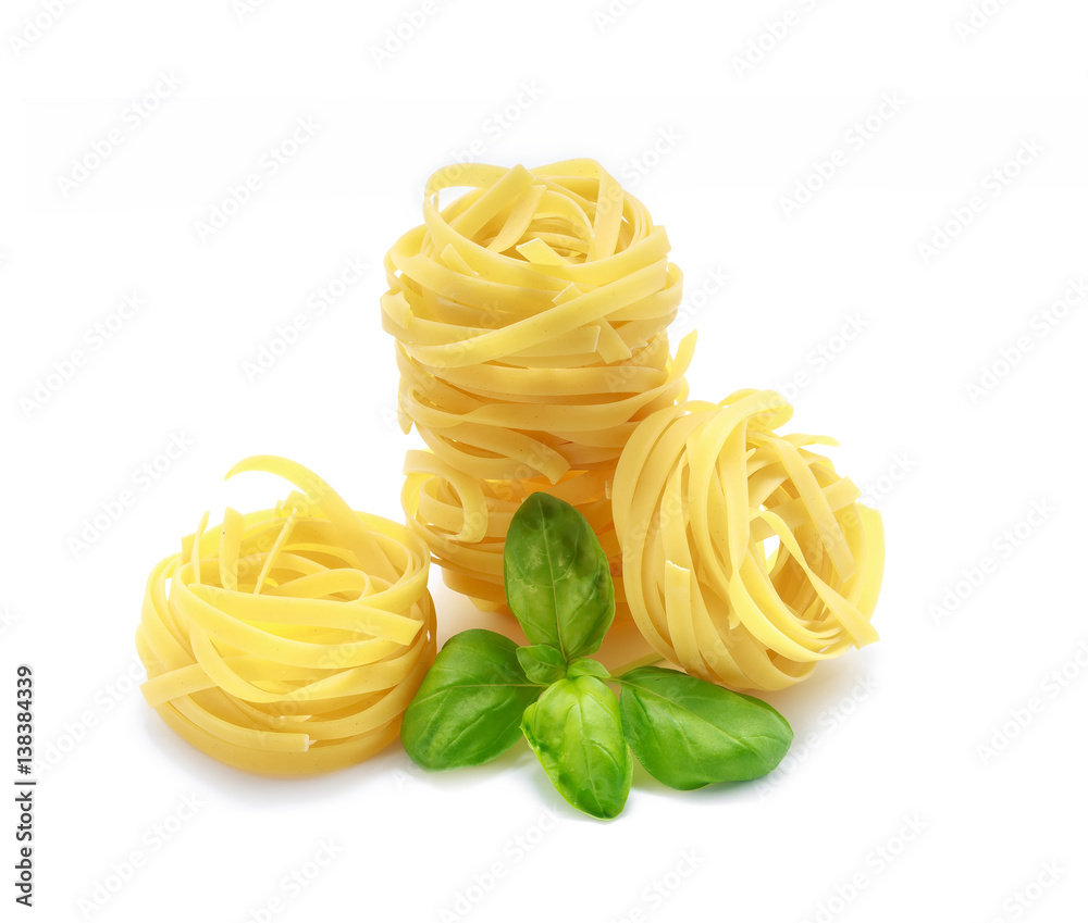 Fettuccine pasta with basil on white background Fettuccine pasta with basil on white background