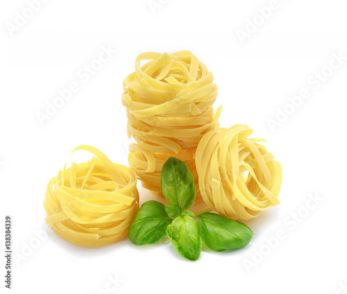 Fettuccine pasta with basil on white background