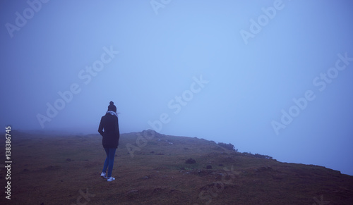 chica joven caminando hacia la niebla
