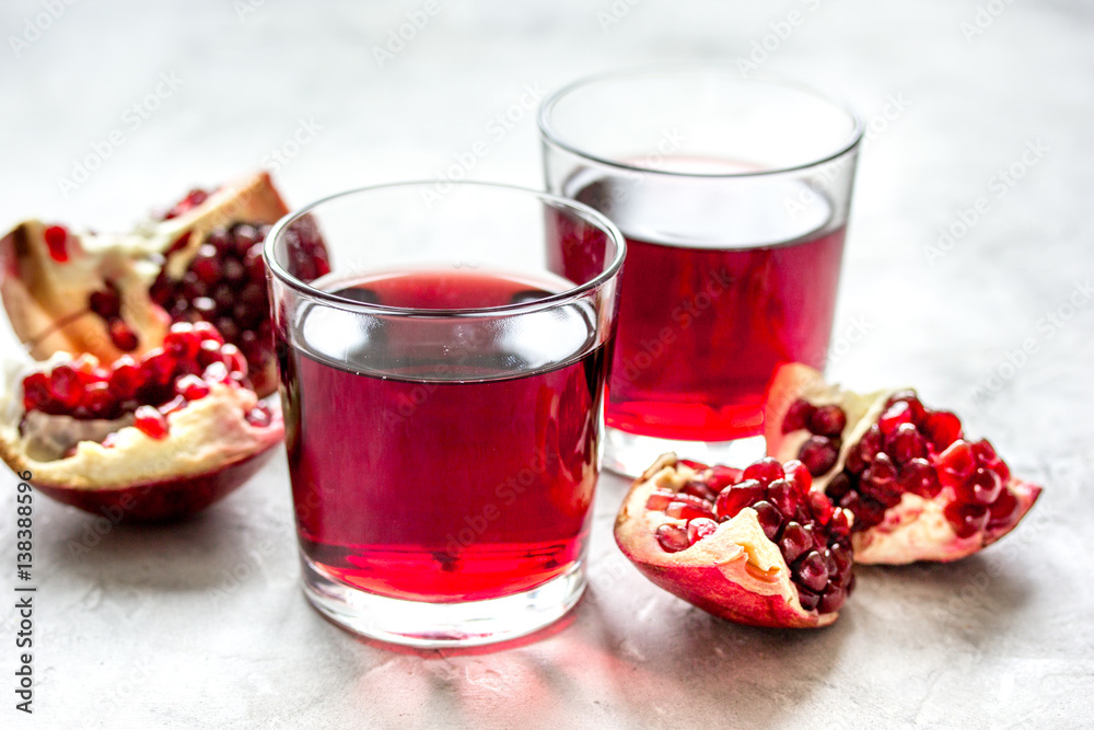 glass of pomegranate juice with fresh slices on stone background glass of pomegranate juice with fresh slices on stone background