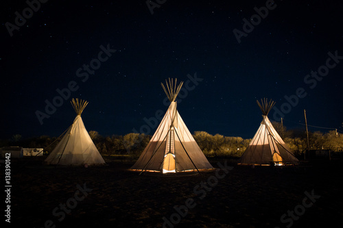 Tipis illuminated at night