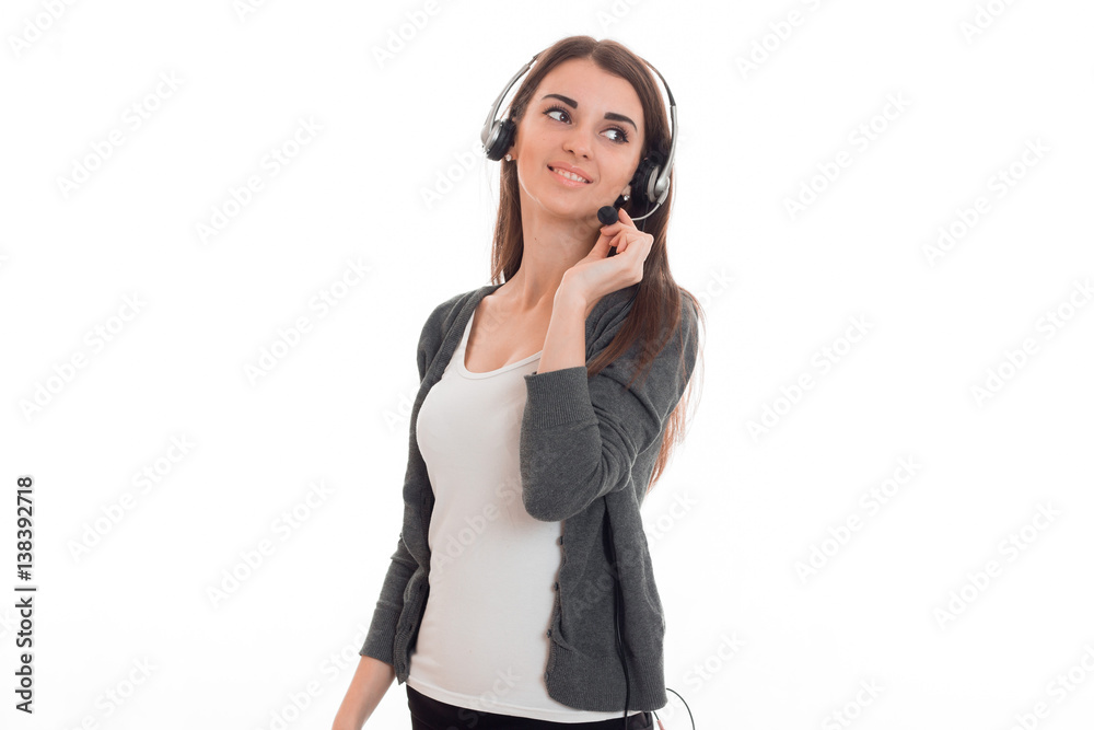young pretty business woman in uniform with headphones and microphone looking away and smiling isolated on white background young pretty business woman in uniform with headphones and microphone looking away and smiling isolated on white background