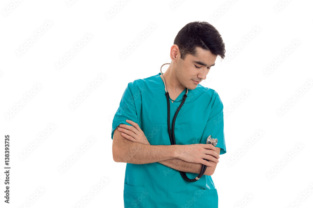 portrait of pretty brunette male doctor in blue uniform with stethoscope posing isolated on white background portrait of pretty brunette male doctor in blue uniform with stethoscope posing isolated on white background