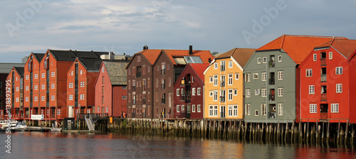 bunte Speichergebäude auf Holzpfeilern spiegeln sich im Wasser der Nidelva in der Altstadt von Trondheim, Süd-Trondelag, Norwegen photo