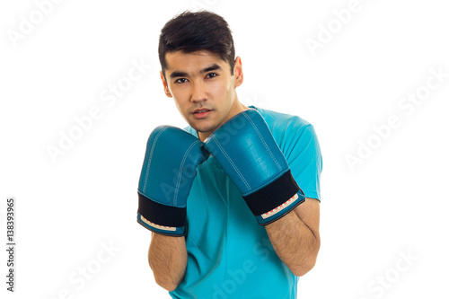 portrait of elegance sportsman in blue gloves and uniform practicing boxing on camera isolated on white background © ponomarencko