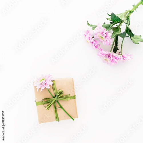 Craft gift box and flowers on white background. Flat lay, top view. Floral background. © artifirsov