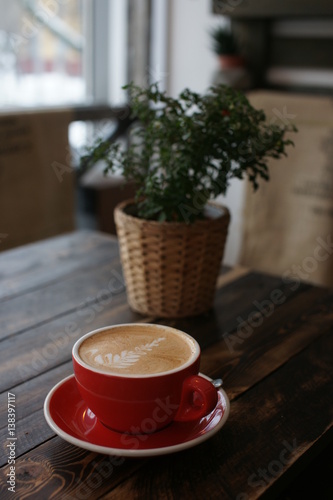 Fototapeta Naklejka Na Ścianę i Meble -  A large red coffee mug on a wooden table.