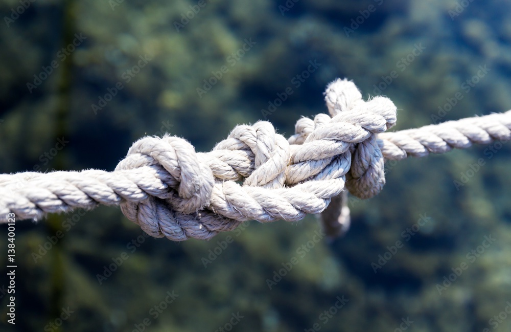White rope with a knot on blue sea background