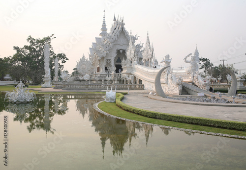 CHIANG RAI, THAILAND -  February 27, 2010: beautiful and amazing Wat Rongkhun (White temple) is reflected in the lake. White temple, Chiang Rai, Thailand.
