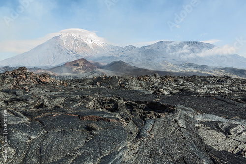 The active lava flow from a new crater on the slopes of volcanoes Tolbachik (background volcanoes Ostry Tolbachik (left) and Plosky Tolbachik (right) - Kamchatka, Russia photo