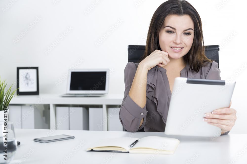 Front view of woman in gray with a tablet Front view of woman in gray with a tablet
