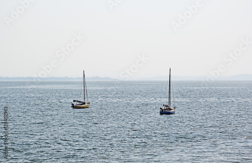 Morning scene of two sailboats anchored in outer sea in Dona Paula in Goa, India