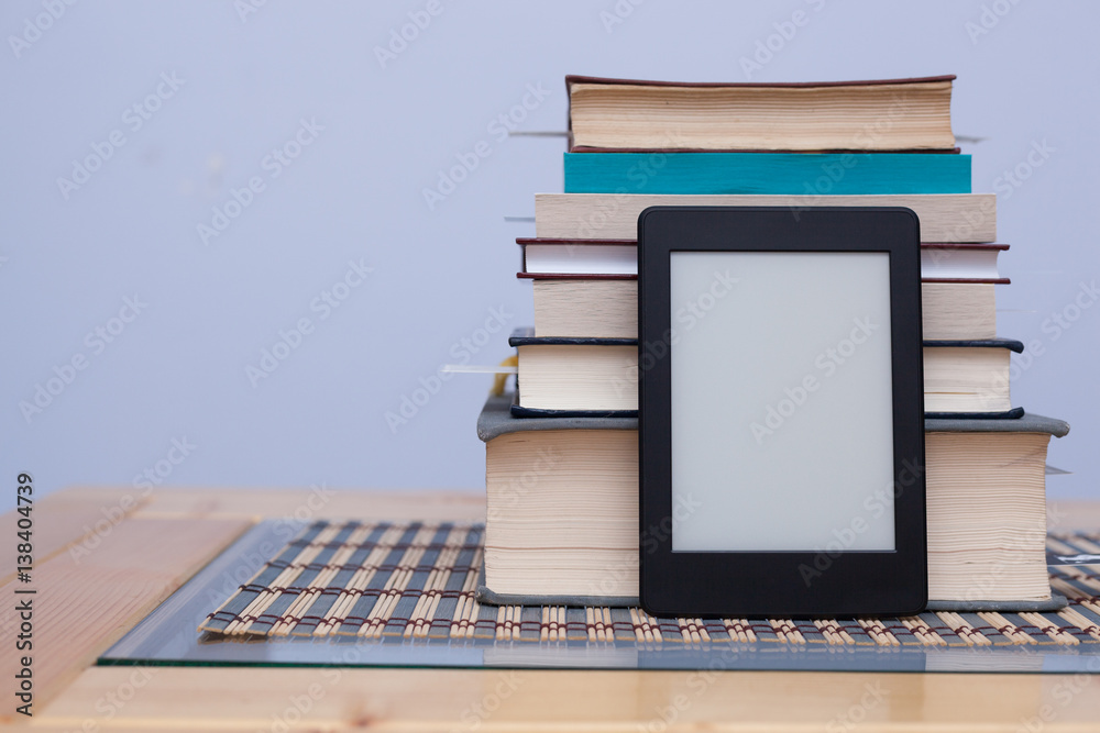Fototapeta premium Blank eReader in front of a tower of books with bookmarks