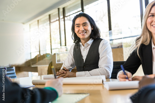 Fotografie Cheerful architect worker with architectural team at group meeting table