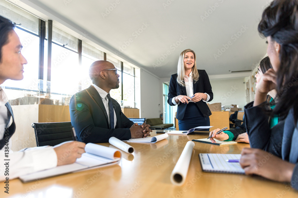 Female businesswoman creative marketing manager president presenting in front of group Female businesswoman creative marketing manager president presenting in front of group