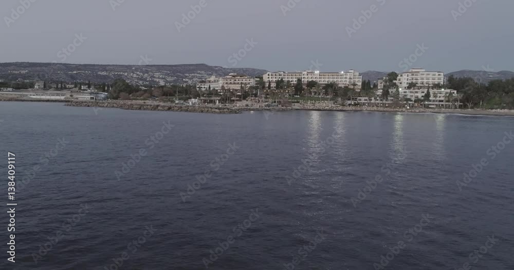 Aerial view of the island of Cyprus at dusk. Flying over hotels situated at the seaside and above beautiful calm Mediterranean sea right after sunset. Aerial view of the island of Cyprus at dusk. Flying over hotels situated at the seaside and above beautiful calm Mediterranean sea right after sunset.