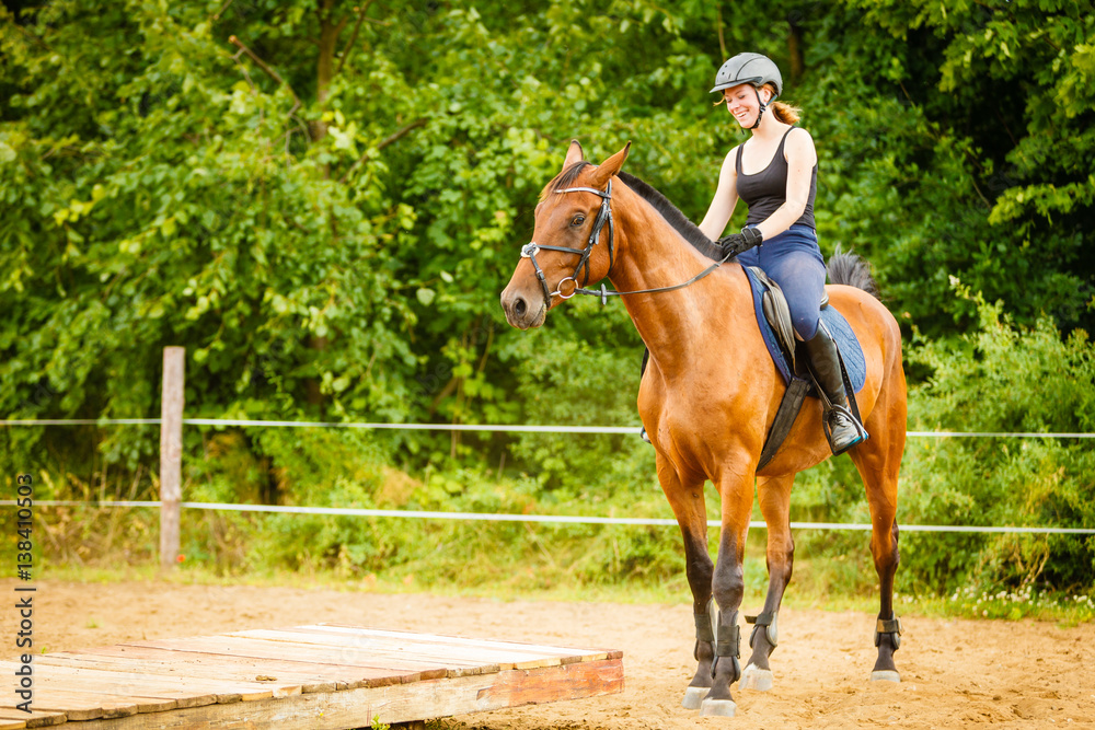 Jockey girl doing horse riding on countryside meadow Jockey girl doing horse riding on countryside meadow