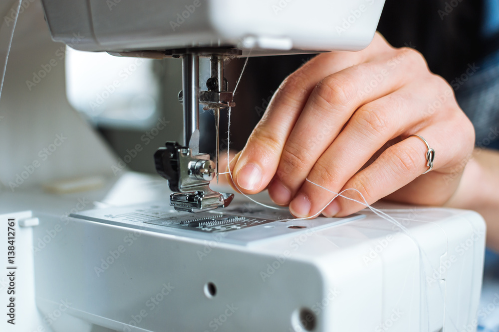Woman working on sewing machine. Close up view