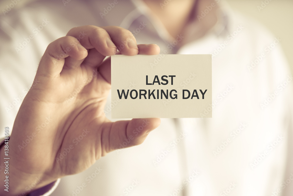 Businessman holding LAST WORKING DAY message card